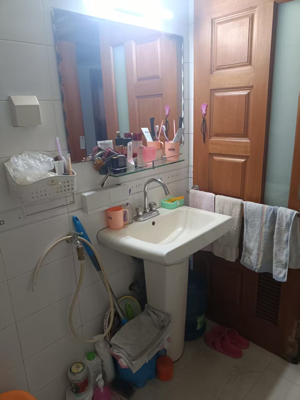 木综厂宿舍卫生间改造前洗衣区角落：20年前的小白砖与外露管线，老装修痕迹明显